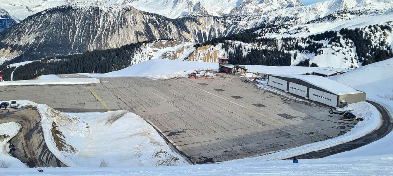   Die Start- und Landebahn des Bergflughafens in Courchevel in den französischen Alpen mit den schneebedeckten Bergen im Hintergrund