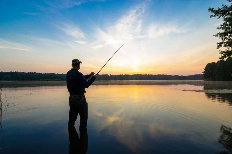   Silueta rybáře při východu slunce